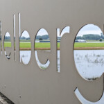 Binnenvaartschip zichtbaar door een naambord van gemaal Laag Helbergen bij Brummen.